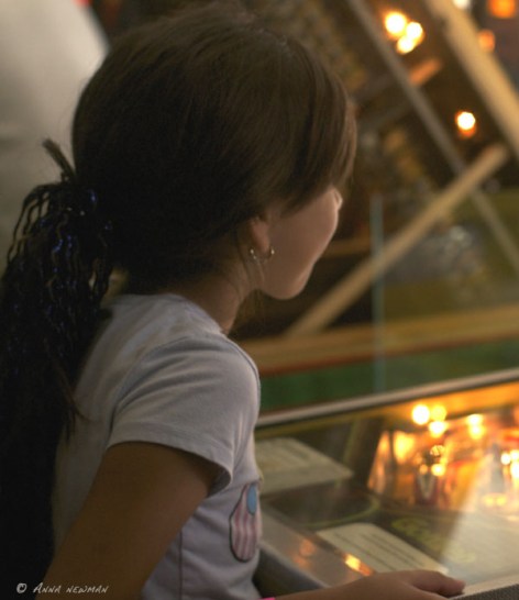 girl plays pinball